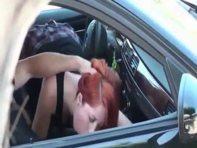 Redhead in plaid skirt gives blowjob in the car