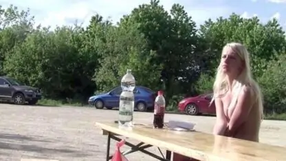 Naked girl having lunch at picnic table